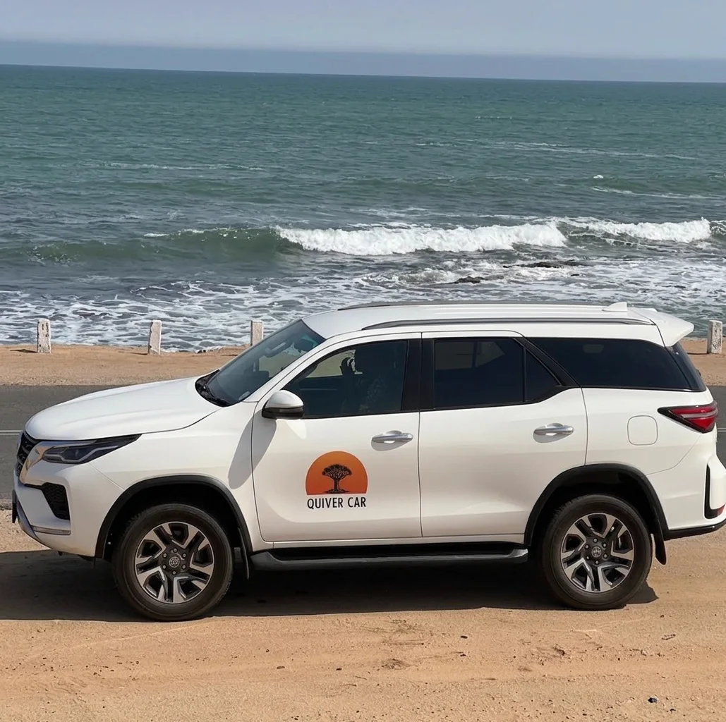 The Quiver Car Rental Toyota Fortuner parked on the sand beside the Atlantic surf